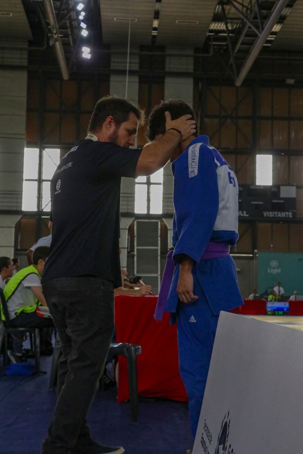 Apoio do professor ao aluno no ginásio de competição